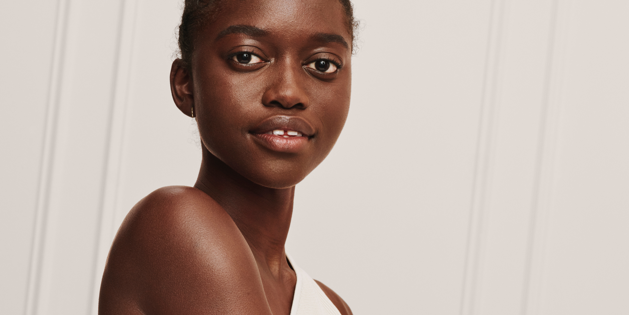 Medium close up image of dark skinned model with clear skin.